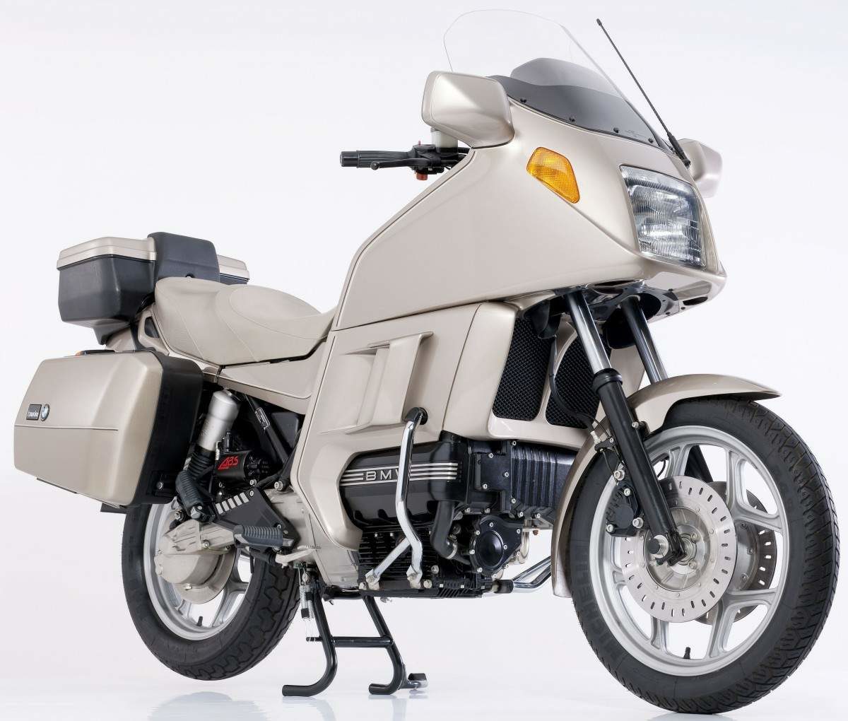 Dit weekend vonden we op ons logeeradres in Zeeland - ga nu nog naar Cadzand Bad voordat de Belgen het helemaal hebben over genomen - een stapel oude motorbladen. We geloven Moto 73 nog bestaat. Dat zou terecht zijn. Want in 1983 schreef dat blad al over de BMW K100 en K75. Ze hadden dus toen al kijk op klassiekers. Dat de tijd toen nog veel ontschuldiger was blijkt uit de ronkende tekst waarbij er sprake is van met meterslange telelenzen vrstopt op de loer liggen spieden naar de nieuwe BMW's. Met de ogen van vandaag zir je dat de fotograaf gewoon met een kop koffie in zij hand en een sjekkie in zijn mondhoek om de machines heeft mogen drentelen. De suggesties over de techniek worden ook wat geheimzinnig gebracht, maar lijken eerder keurig overgepend uit het lijstje dat het journaille te beschikking was gesteld. Intussen was de K100 van BMW indertijd hot news. De machine was natuurlijk zo groot, zwaar en snel als je van een topmodel mocht verwachten. Maar hij liet ook duidelijk zien dat de Duitsers zich niet blind aan het boxerconcept gebonden achten. De K100 - en de K75 - warren zo innovatief als er alleen in Europa gedacht en gebouwd kan worden. De liggende viercilinder met zijn kop aan de ene, en zijn carter aan de andere kant was een sterk staaltje van 'out of the box' denken. Een laag zwaartepunt en een optimale bereikbaarheid voor service en onderhoud. Na de introductie groeide de 'baksteenblokken' uit tot een verkoopsucces dat het hart was van een hele serie motoren. Maar op een gegeven moment was het nieuws er af en werden de K100's en inmiddels de K75's door de tijd ingehaald. Het bleven fantastische motorfietsen, waarbij de K75 eigenlijk net iets lekkerder reed dan zijn grote broer. Nog maar heel kort geleden zaten de prijzen op wat intussen het dieptepunt was. 'Tegen elke prijs' was nog net een brug te ver maar voor omstreeks de 800-1000 euro had je een riante keuze uit K100's en K75. Hier twee straten verder bleek een absoluut smetteloze vroege K100 met volledige onderhoudshistorie alleen interessant voor iemand die er een café racer van wilde maken en die de eigenaar vroeg wat er nog van de prijs af kon als hij de kuip en koffers er niet bij zou nemen. Die tijd is intussen vorbij aan het gaan. Een nette K100 of K75 koop je nog steeds voor weinig, maar je krijgt geen geld meer mee als je er eentje mee neemt. Het grappige is dat de opleving in de verkoop van deze liggende drie- en viercilinders niet eens komt omdat wij reguliere motorrijders de klassieke waarde van de 'bricks' zijn gaan waarderen. Momenteel zijn de kopers van deze generatie BMW's mensen die er blij van zin café racers en scramblers van maken. Het is voor BMW liefhebbers met visie nu dus zaak om een zo gaaf mogelijk, origineel exemplaar te scoren en dat te koesteren