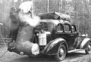 Ook voor uw houtomobiel: De Imbert houtgasgenerator Rijden op houtgas. Daar is een hele installatie voor nodig. En omdat houtgas laag calorisch is scheelt het rijden van een hauto zo’n 40+ % vermogen ten opzichte van een benzineblok. Maar er zijn dappere pogingen gedaan. Doorgaans uit een soort van noodzaak. En de boordelektronica van een moderne auto zou er helemaal van overstuur raken. De meeste houto’s reden met behulp van een gasfabriek volgens Imbert Die Imbert houtgas generator is een uitvinding van Georges Imbert. Hij ontwikkelde het principe zo’n 100 jaar geleden al. Tijdens de tweede wereldoorlog waren er meer dan een miljoen houtvergassers onderweg, bijna allemaal volgens het Imbert principe. Na de oorlog kwam al snel de benzineproductie weer op gang en nam men zonder spijt afscheid van de houtvergassers. Kennis en ervaring zijn daarbij vrijwel direct grotendeels verloren gegaan. Van roeg opstaan (opwarm tijd) en het krijgen van vieze handen werd ook al zondr spijt afscheid genomen. Tijdens de koude oorlog gingen de Zweden wel door met de ontwikkeling van het systeem. Maar buiten de publicatie van ondrzoeksdocumentatie is er weinig mee gedaan. De insteek was immers dat het alleen nodig zou zijn om tijdens een crisis terug te kunnen grijpen op brandstof voorziening uit eigen bron, op houtvergassing, omdat Zweden nagenoeg geen fossiele brandstoffen heeft. Maar hout hebben ze in Zweden in overvloed. Al die bomen staan er gewoon op te wachten tot ze zich nuttig kunnen maken. De energiecrises in de jaren zeventig hebben indertijd ook weer geleid tot een kleine oplevingen in de interesse in houtvergassers voor verbrandingsmotoren, die net zo snel weer wegzakte toen het economisch weer wat beter ging. Alleen bij de Finnen is de mobiele houtvergasser nooit helemaal weggeweest. Niet in grootschalige, door de overheid gesubsidieerde projecten, maar door het enthousiasme van een kleine groep mensen. Zij hebben de doorontwikkeling van de Zweden verder verfijnd. Daarmee blijft het ontwikkelen van houtvergassers iets uit de wereld van idealisten, techneuten en milieudromers. Want rijden op houtgas: Dat doe je nog steeds niet voor je plezier. Het principe De “gasfier unit” is gevuld met houtblokjes. De nozzles doseren de lucht. Het motorvacuüm zorgt voor “trek” in het hele systeem. Indirect regelt het motortoerental en de motorbelasting de geproduceerde hoeveelheid gas en daarmee de toegevoerde lucht. Bij de een doorsnee generator wordt het gas hoog afgenomen om asdeeltjes de tijd te geven achter te blijven en om de houtvoorraad op te warmen. Van daaruit gaat het gas door een koeler om het te ontwateren en het volume te reduceren. Denk “Intecooler’. Door de volumeverkleining en verwijdering van waterdamp neemt de energie-inhoud toe. Na de filtertrein kan het gas via een eenvoudige gas/luchtmenger naar de motor. Een ventilator is nodig om kunstmatige trek op te wekken voor de start van het vergassingsproces. Moderne Imbert units werken wat anders. De generator heeft een condenserende mantel om de bunker, om de de houtvoorraad verder voor te drogen en overtollig water af te voeren. Een cycloon verwijdert de grove asdeeltjes. Een glasfiber doekenfilter haalt de rest van de ongerechtigheden eruit. De koeler ontwatert ook hier het gas. Tijdens de opstart blaast de blower het gas nog voor de filtertrein naar buiten, om verstopping van het filter door teer en waterdamp uit de nog koude oxidatiezone te voorkomen. Vergeleken met de oorspronkelijke Imbert is er buiten het principe wel wat veranderd. Veel aandacht is besteed aan het voorverwarmen van de primaire lucht, om de oxidatietemperatuur verder te verhogen. Dit schept echter weer problemen, want niet alle materialen kunnen deze temperatuur weerstaan. Al met al nogal wat complexer dan vroeger, maar met als resultaat een teervrij, schoon gas. Met behoud van de eerder genoemde nadelen. En de Airmiles kun je ook op je buik schrijven.